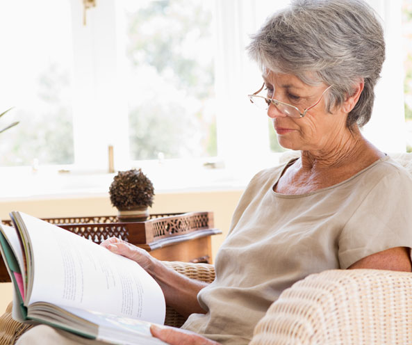 Elderly woman on couch book